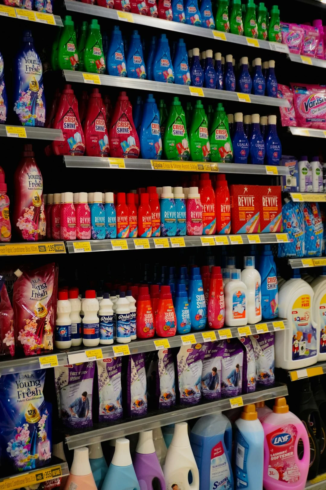 Person using spray bottle and cloth for cleaning a kitchen shelf, ensuring hygiene and cleanliness.